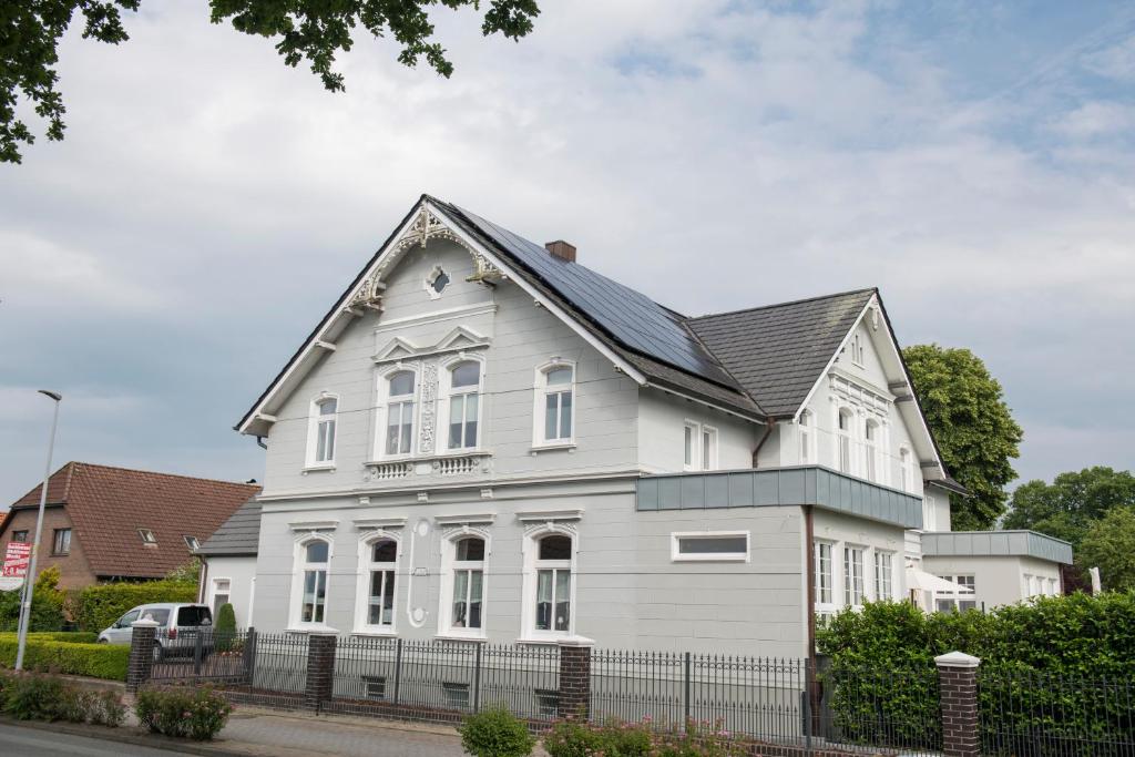 a white house with a black roof at Pension Onken in Bockhorn