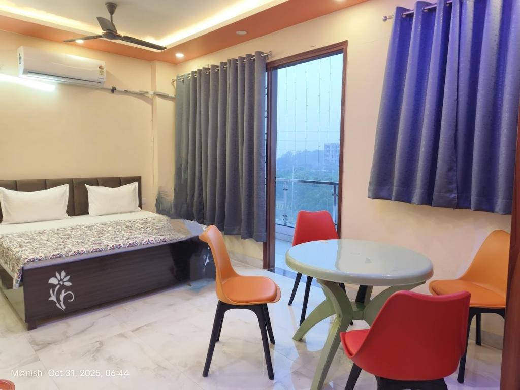 a bedroom with a bed and a table and chairs at Fng Guest House in Noida
