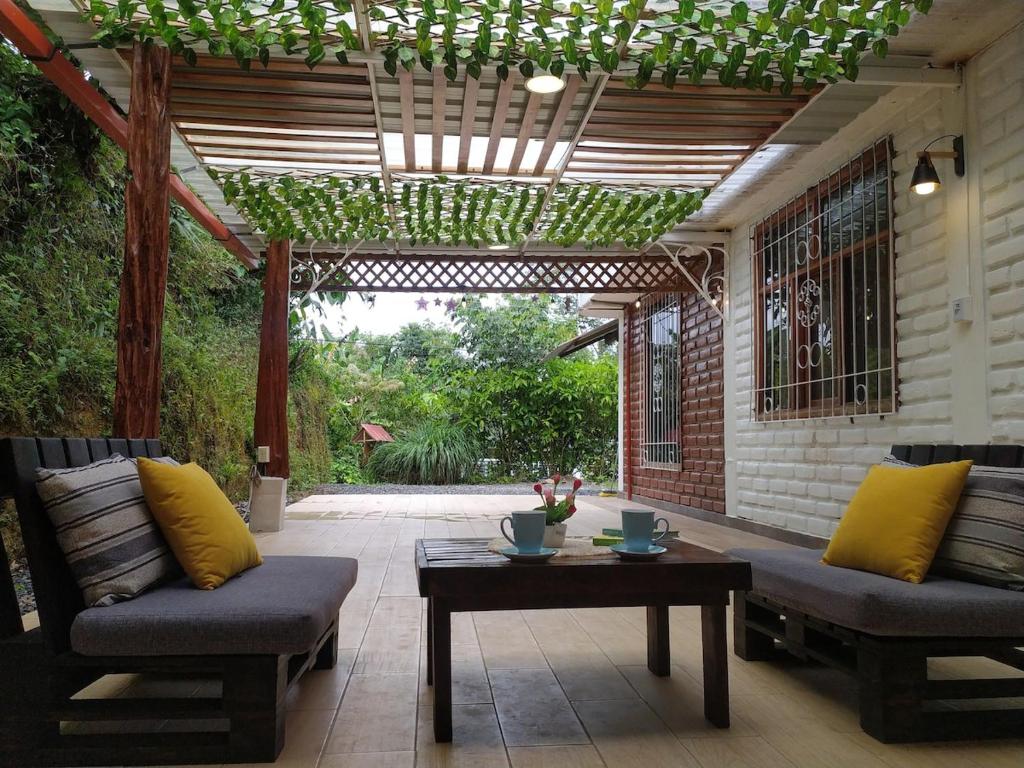 a patio with two chairs and a table and a pergola at Relax Home in Puyo