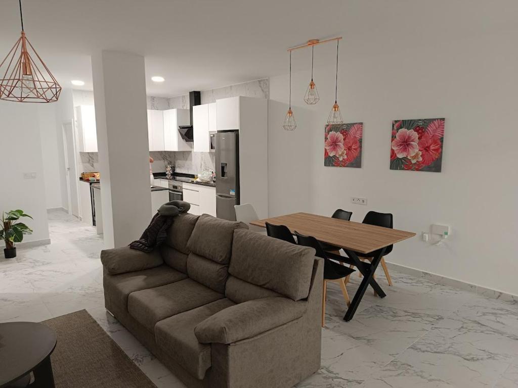 a living room with a couch and a wooden table at Sylvia Apartman in La Mata