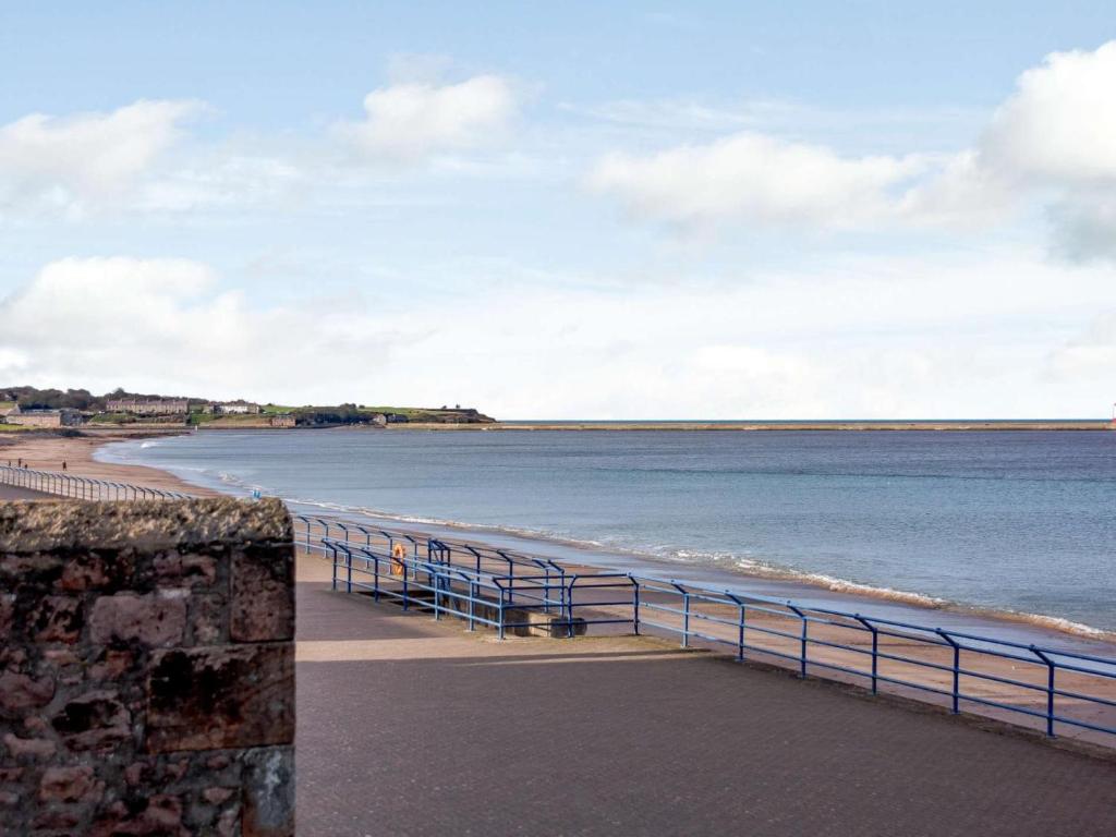 a view of the beach with a blue fence at 2 Bed in Berwick-upon-tweed oc-82189 in Spittal