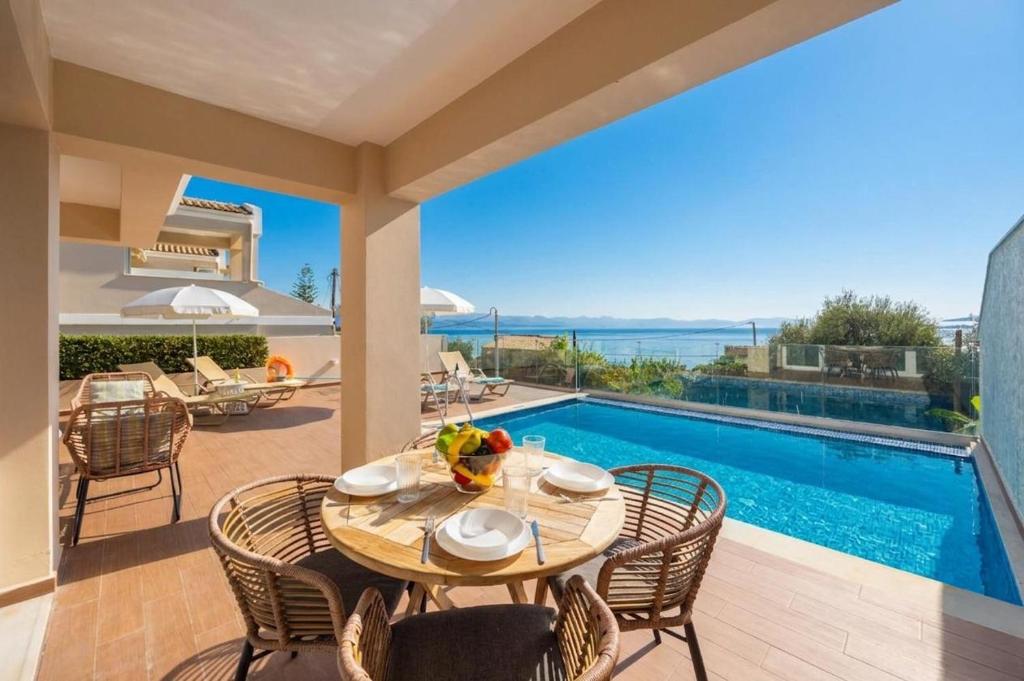 a patio with a table and chairs and a swimming pool at Villa Damian in Barbati