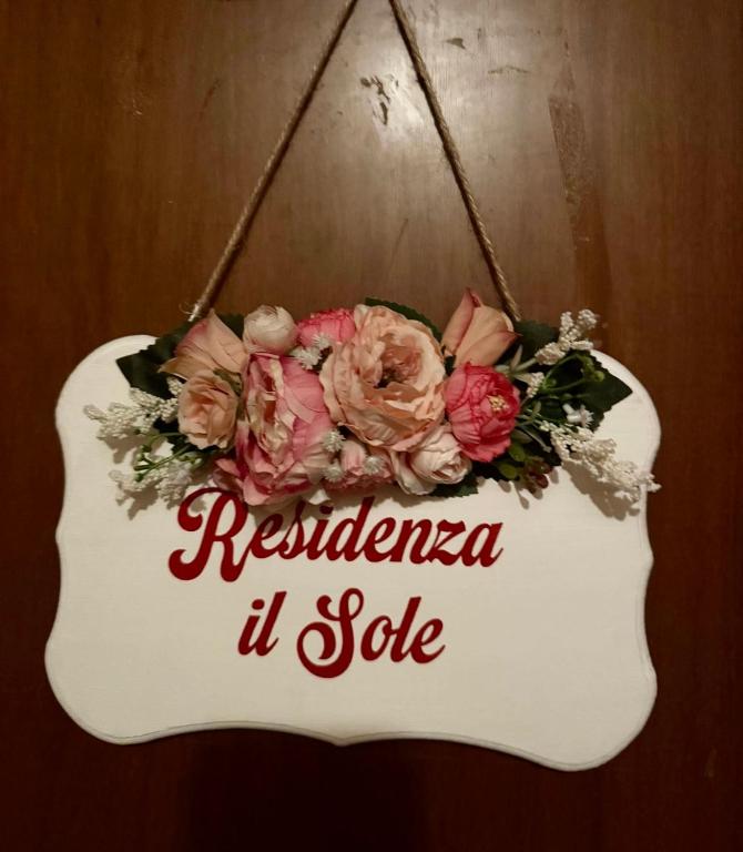 a sign with a bouquet of flowers on a door at Residenza il Sole in Bologna