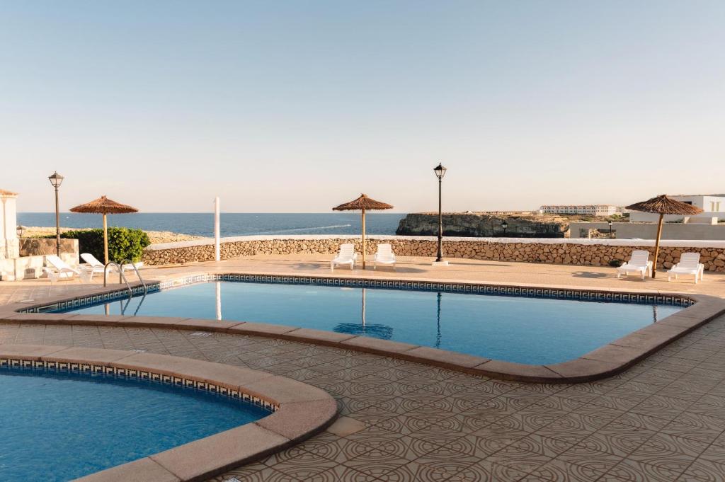 a swimming pool with a view of the ocean at BLUESEA Cabo de Baños in Cala en Blanes