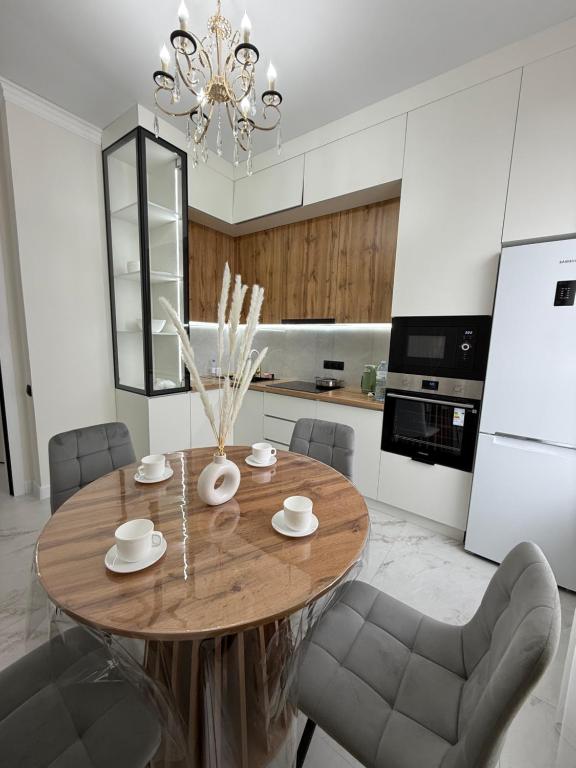 a kitchen with a round wooden table and chairs at Жк Берекелы in Almaty