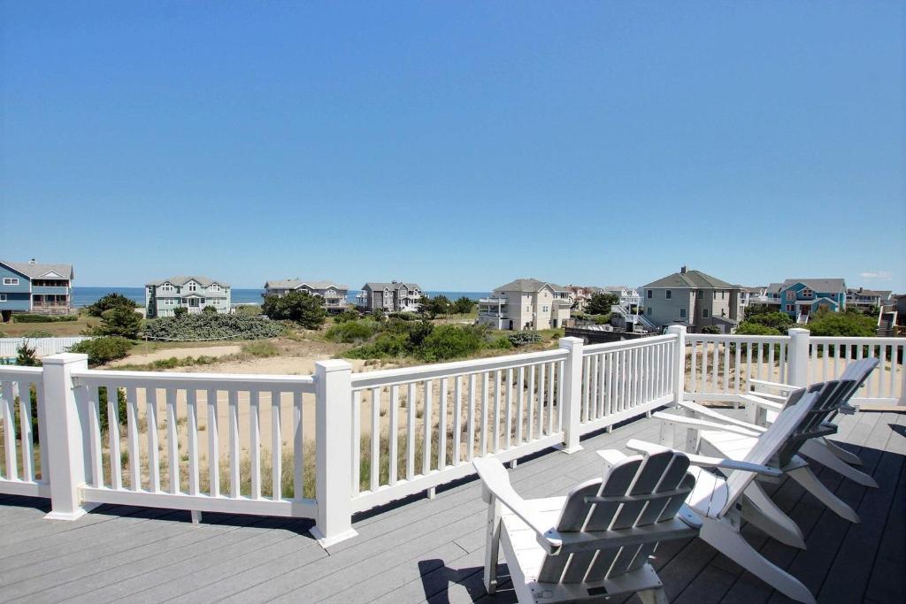 a deck with chairs and the ocean in the background at Buhlers Day Off in Corolla