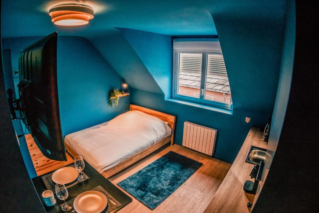 a small room with a bed and a window at La Maison 12 in Valenciennes