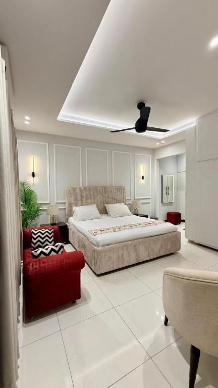 a bedroom with a large bed and a red couch at Luxury Private Room Canal Rd Near Galleria in Faisalabad
