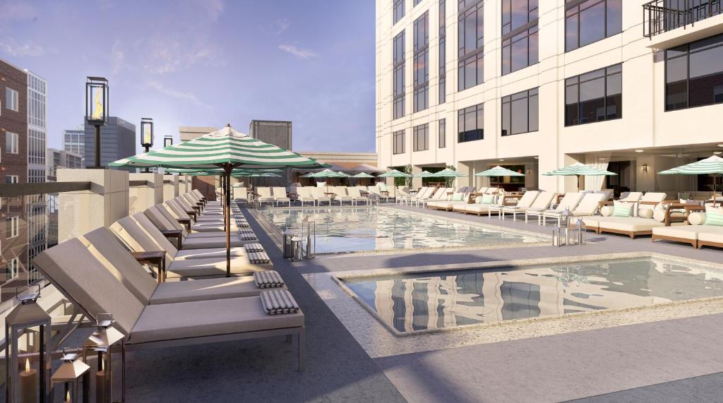 a pool with chairs and umbrellas on a building at Pendry San Diego in San Diego