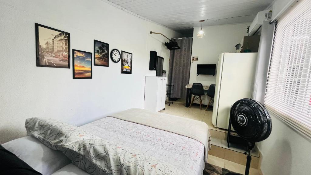 a room with a bed and some pictures on the wall at Kitnet com ar-condicionado e entrada privativa SC in Itajaí