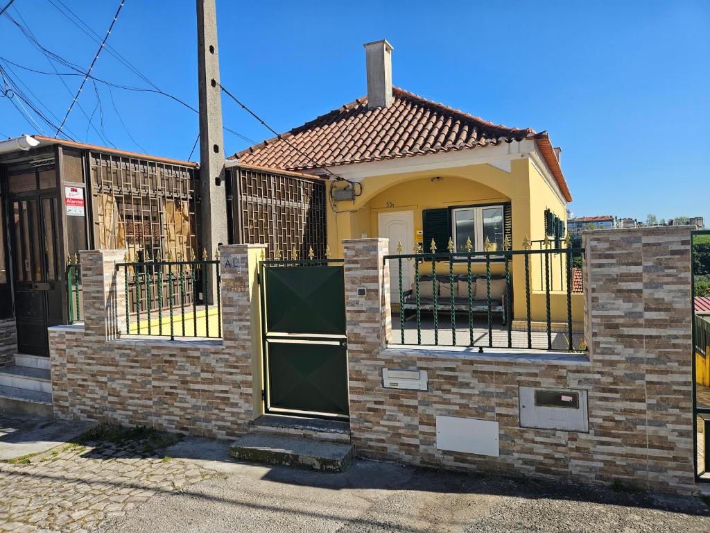 a yellow house with a gate and a fence at Zabava Odivelas in Odivelas