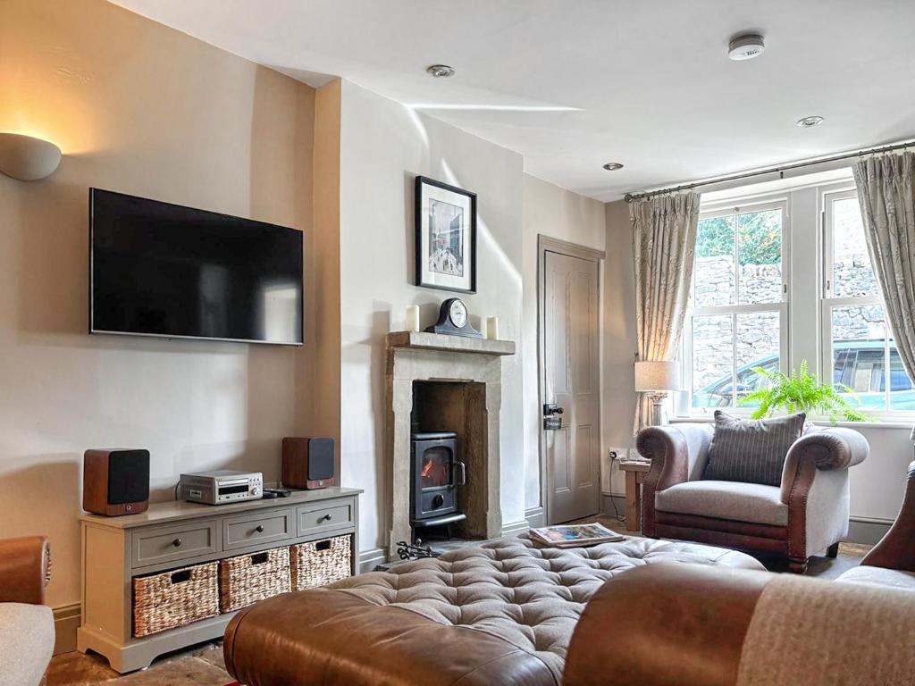 a living room with a couch and a fireplace at Jasmine Cottage in Grassington