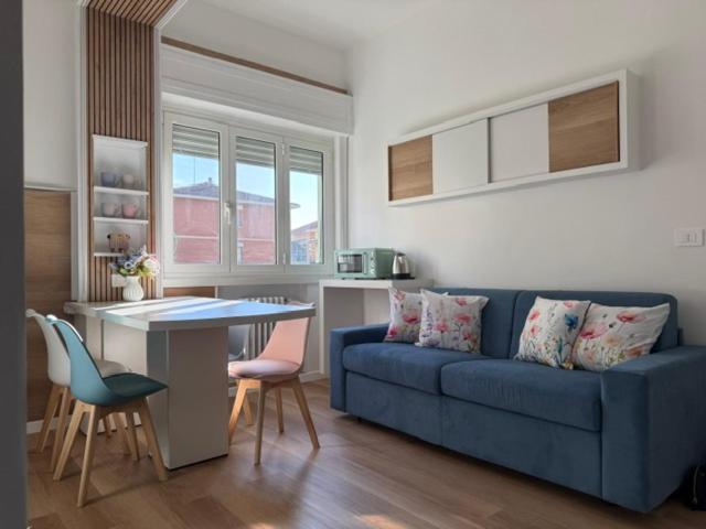 a living room with a blue couch and a table and chairs at Maison Louis in Parma