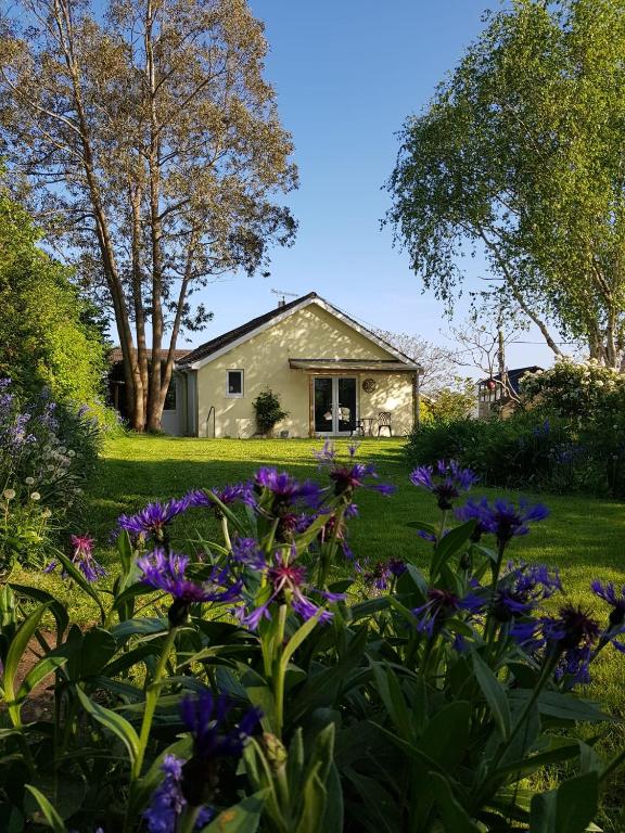 a garden with purple flowers in front of a house at Sundial Cottage in Newton Abbot