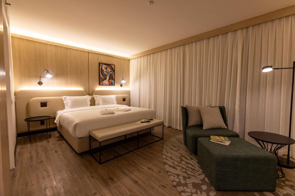 a hotel room with a bed and a chair at Intercity Pamplona - The Universe Paulista in São Paulo