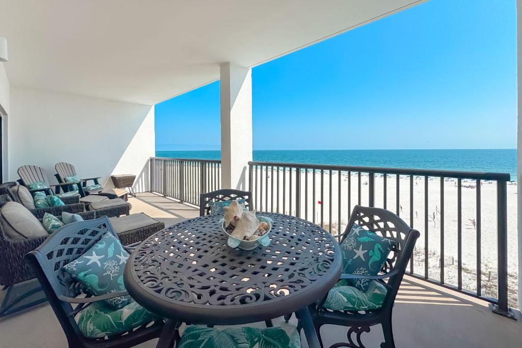 a table and chairs on a balcony with the beach at The Palms West Unit 515 in Orange Beach