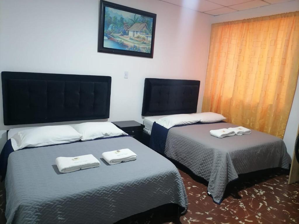 two beds in a hotel room with towels on them at Hotel las vegas Málaga in Málaga