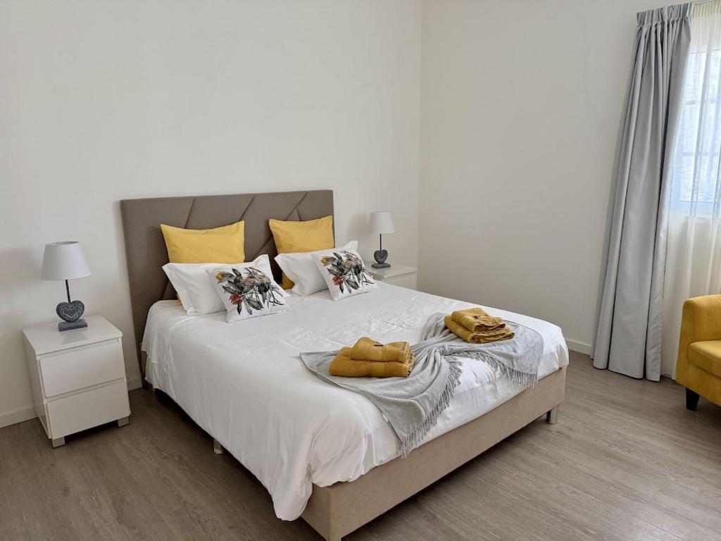 a bedroom with a bed with two towels on it at Harmony Deluxe Accommodation in Água de Pau