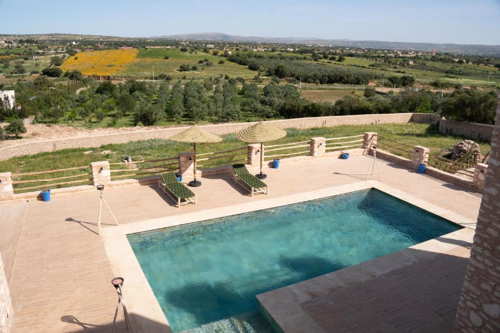 an overhead view of a swimming pool with chairs and umbrellas at Villa Luxury Spacious Moroccan ,Private Pool in Essaouira
