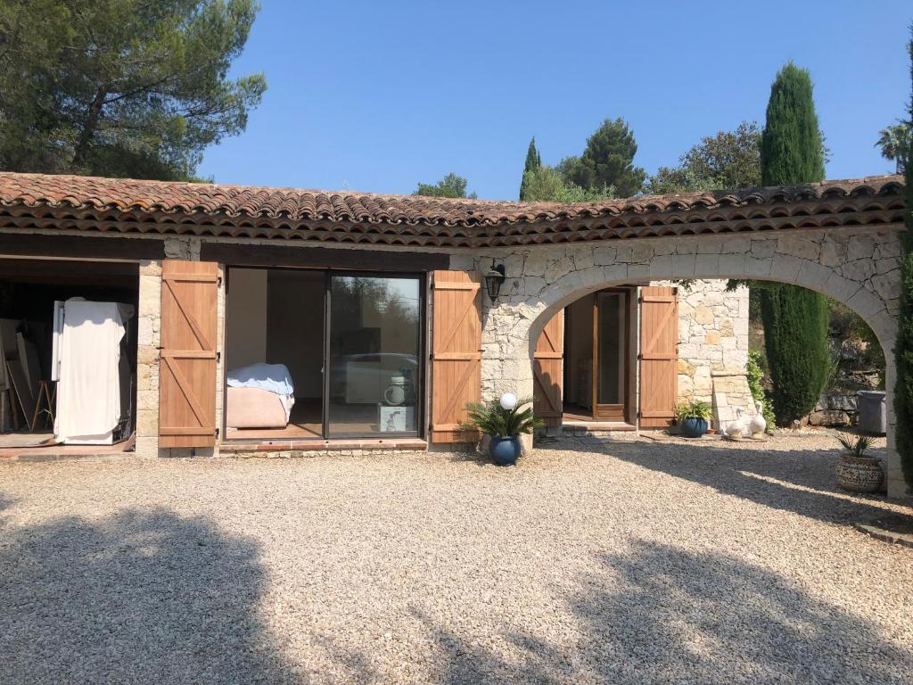 a house with an archway in a yard at La calade in Roquefort-les-Pins