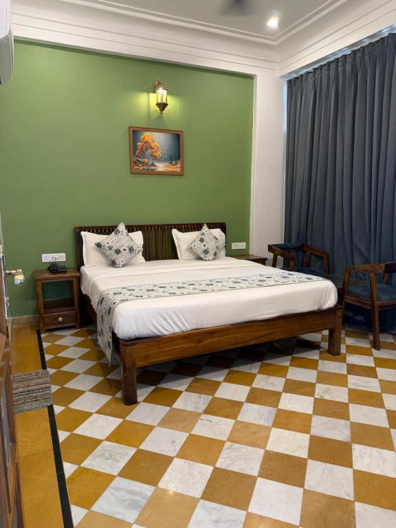 a bedroom with a large bed in a green wall at Vista villa in Pushkar