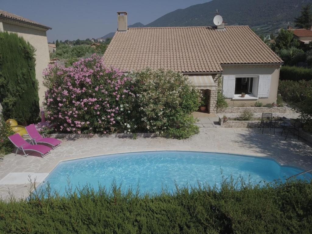 a villa with a swimming pool in front of a house at La Maison d'hôtes Antaram in Nyons