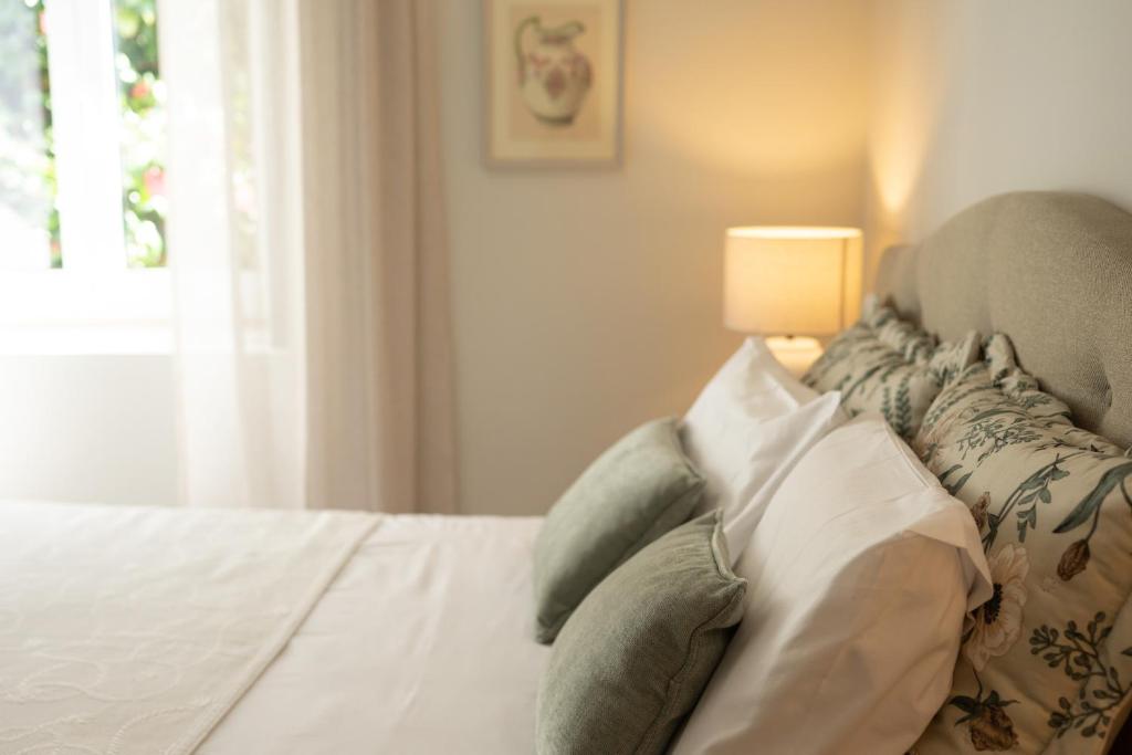 ein Schlafzimmer mit einem Bett, einer Lampe und einem Fenster in der Unterkunft Casa d`Acucanha in Penafiel