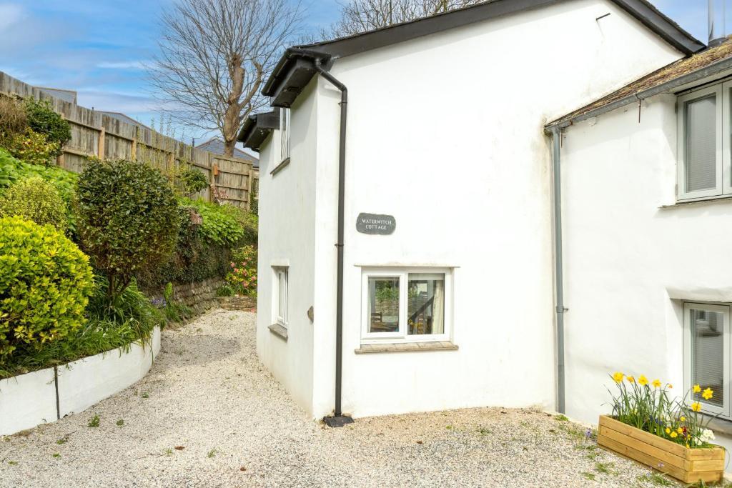 an exterior view of a white house at Waterwitch Cottage in Newquay