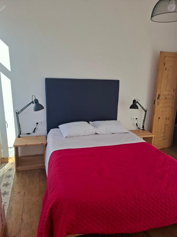 a bedroom with a large bed with a red blanket at Sailor Setubal in Setúbal