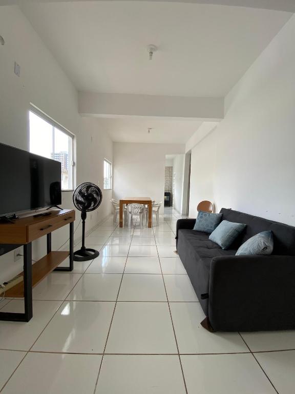 a living room with a couch and a tv at Ed The Rock in Belém