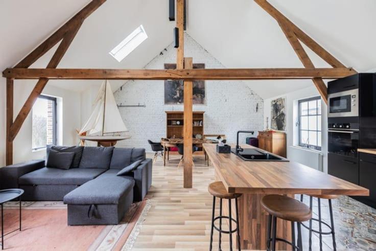 a living room with a couch and a table at Large bright apartment in Lessines