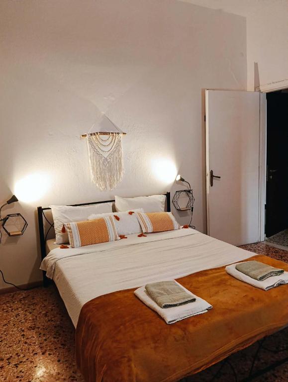 a bedroom with a large bed with two towels on it at Mia Nest in Artemida