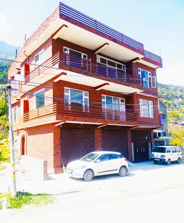 a building with a car parked in front of it at Red Brick Home stay in Kulu