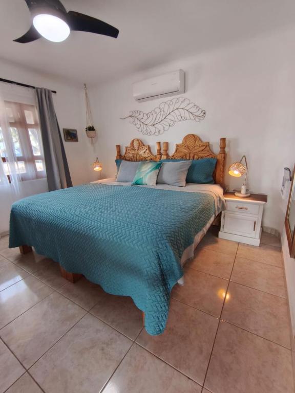 a bedroom with a large bed with a blue blanket at Casa Punta Perula Boutique Hotel in Pérula