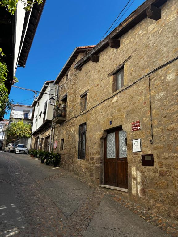 an old brick building with a door on a street at Casa rural Chantal in San Martín de Trevejo