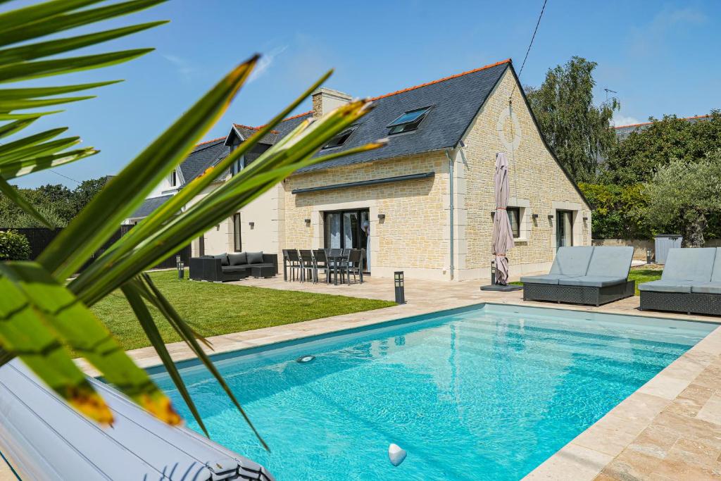 a swimming pool in front of a house at "La Villa Gozforn" avec piscine privée, plages et commerces de la station balnéaire de Beg-Meil à pied! in Fouesnant