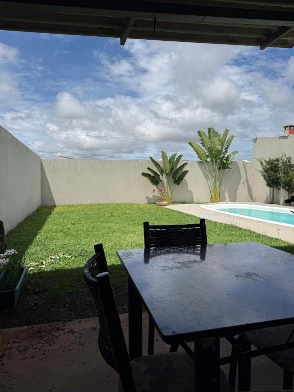 a table and chairs next to a swimming pool at rafaela cardoso souza in Água Boa