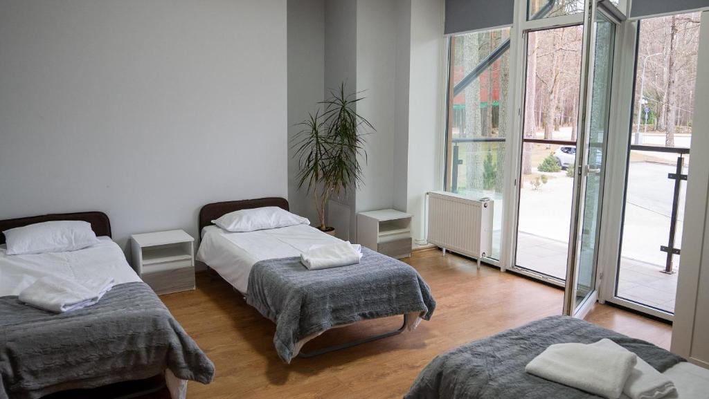 a bedroom with two beds and a large window at Valmiera Park Hostel in Valmiera