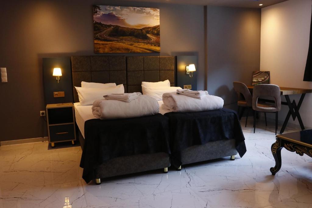 ein Schlafzimmer mit einem großen Bett und zwei Kissen in der Unterkunft NRING VILLA Adenau in Adenau