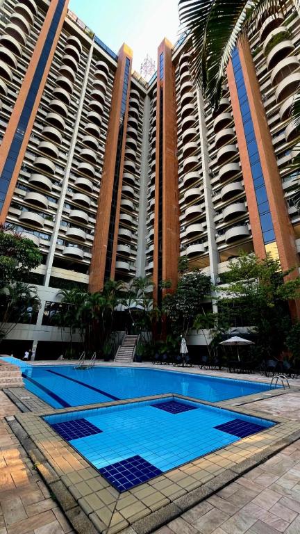 a pool in front of two large apartment buildings at Alphaville Serviced Apartment São Paulo in Barueri