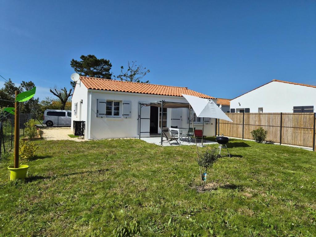 a small white house in a yard at Maison neuve 3 étoiles proche de la mer in La Brée-les-Bains