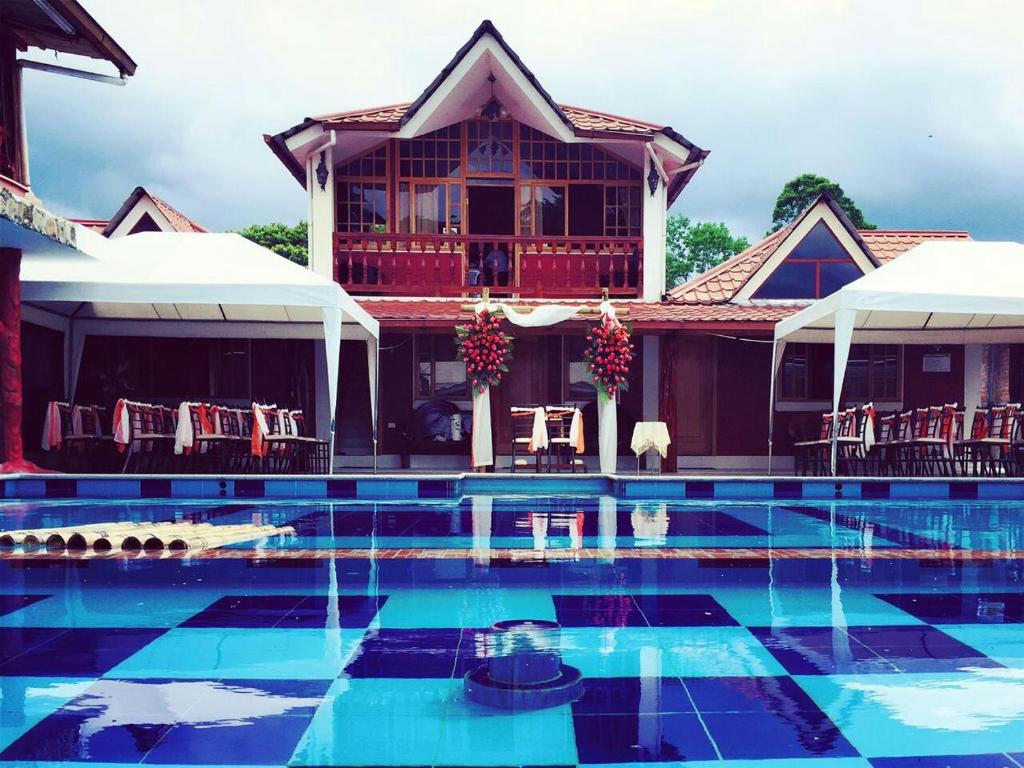 a house with a swimming pool in front of a house at Hosteria Don Elias in Puyo