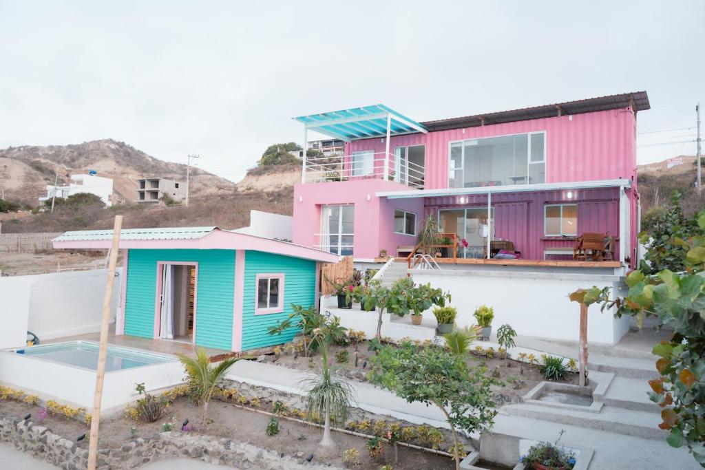 ein Haus mit einem rosa und blauen Haus in der Unterkunft Flamingo Beach Santa Marianita Manta in Manta