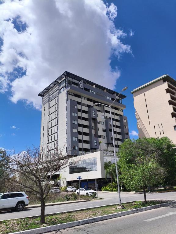 a tall black building with cars parked in front of it at Buyan Departamentos in Mérida