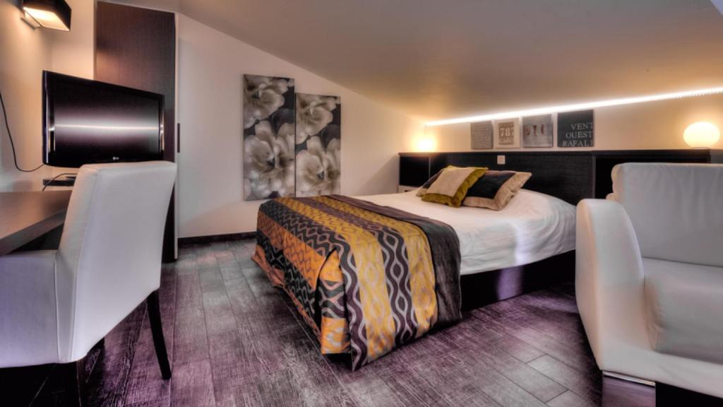 um quarto de hotel com uma cama, uma secretária e cadeiras em AppartHotel Belle Vue em La Louvière