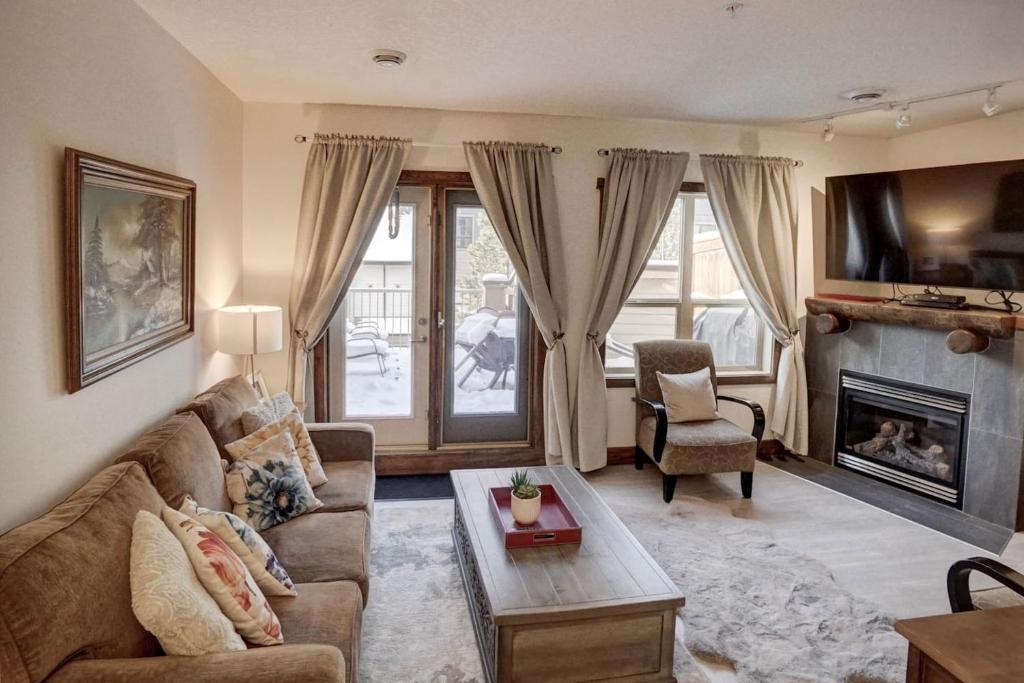 a living room with a couch and a fireplace at Fire Mountain 204 2 Level, 2 bed, great views! in Canmore