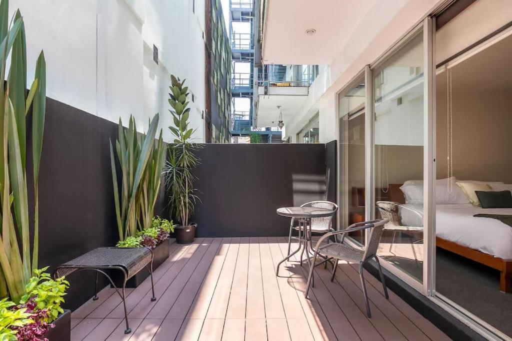 a balcony with a bed and a table and chairs at Chic 2BR Condo in Condesa steps from Parque Mexico in Mexico City