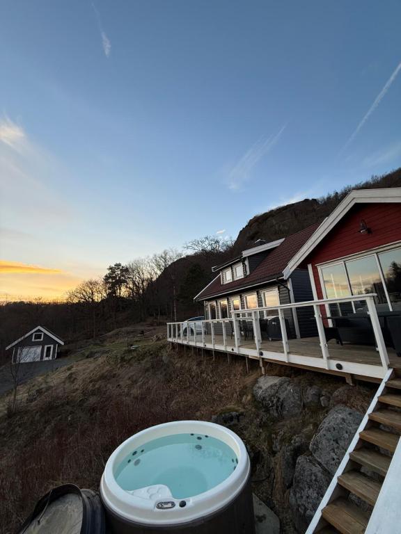a hot tub in front of a house at Landlig hytte med jacuzzi in Lyngdal