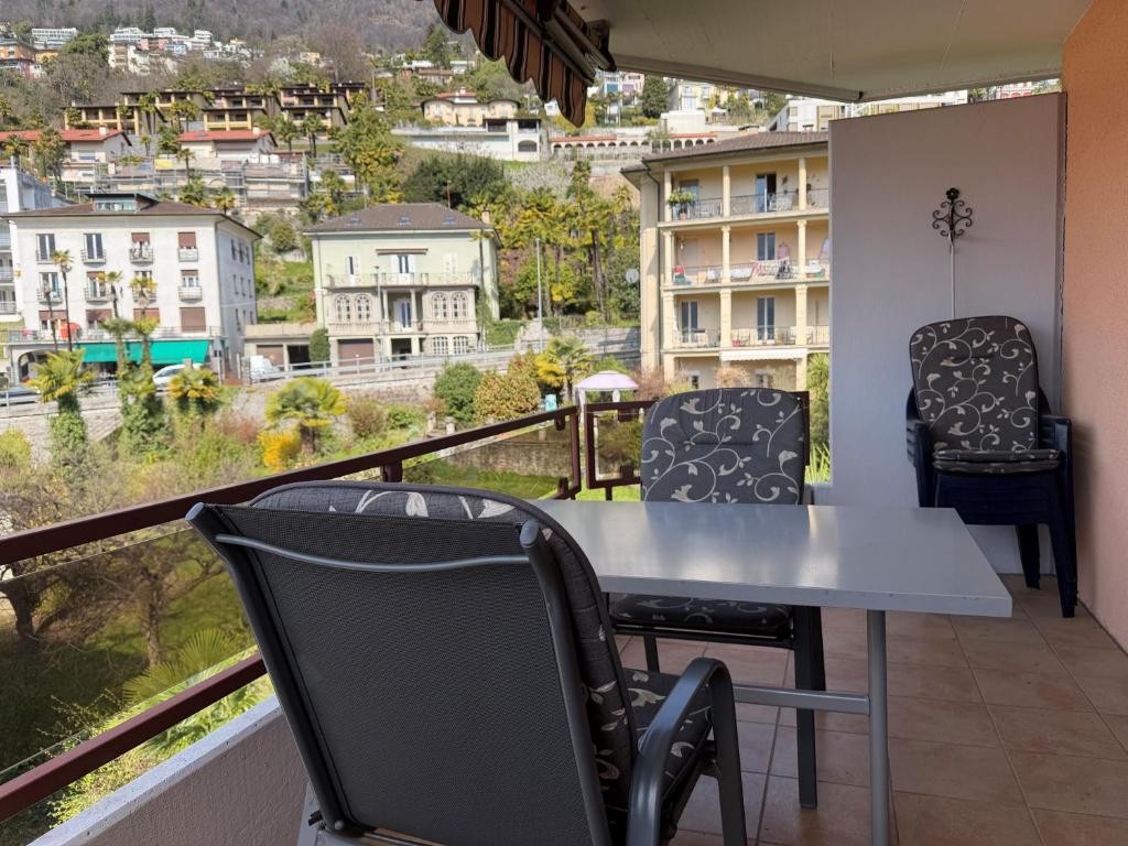 a balcony with a table and chairs and a view at Onyx - 1 5 Zimmer in Muralto