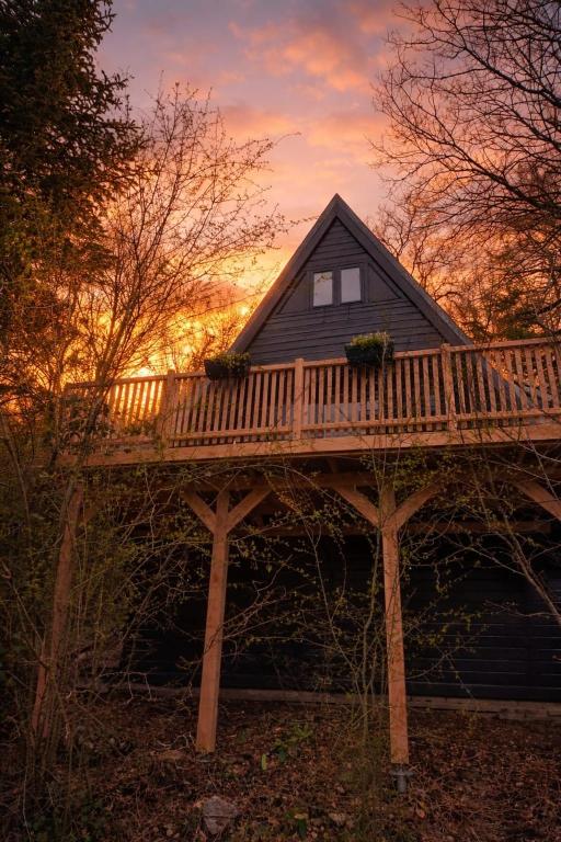 a house with a deck on top of it at 't Grote Egeltje XL chalet 220 in Durbuy